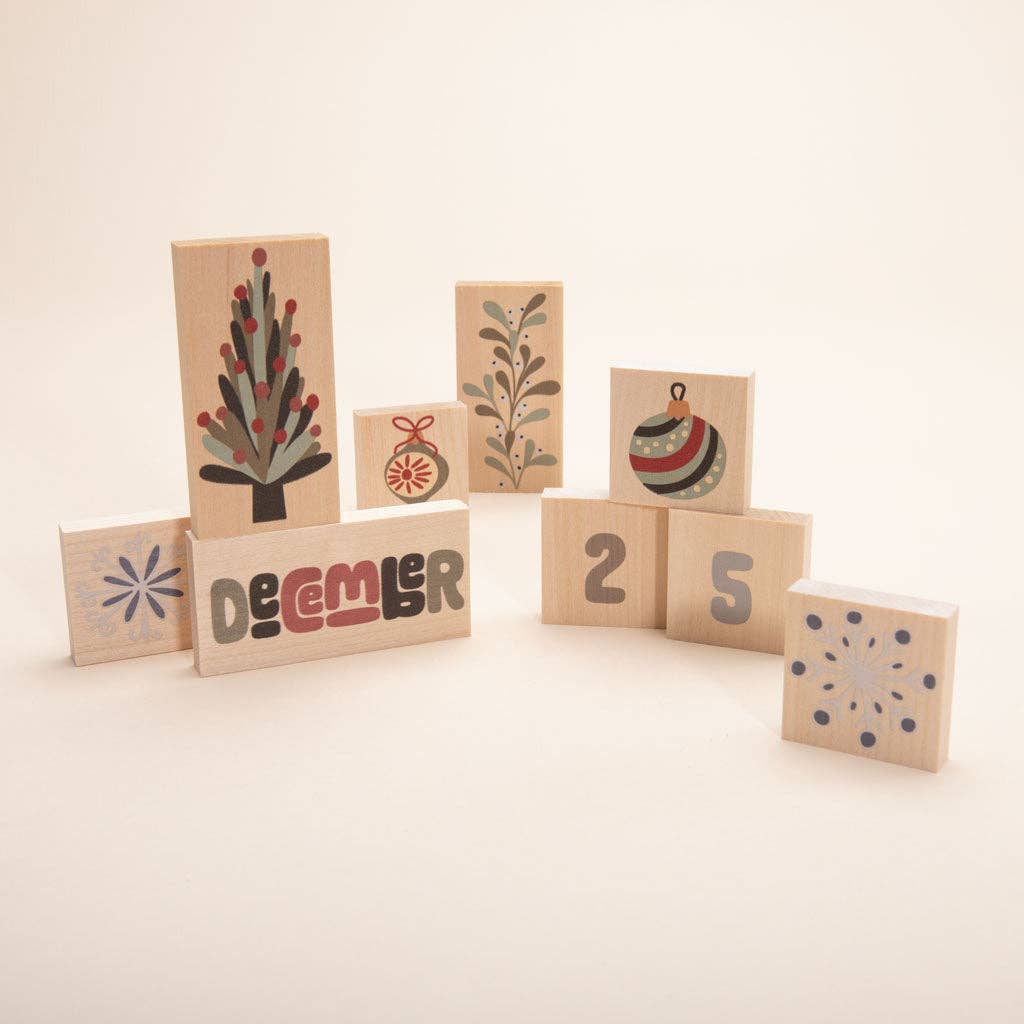 Wooden calendar chips laid out showing months, numbers, and seasonal illustrations
