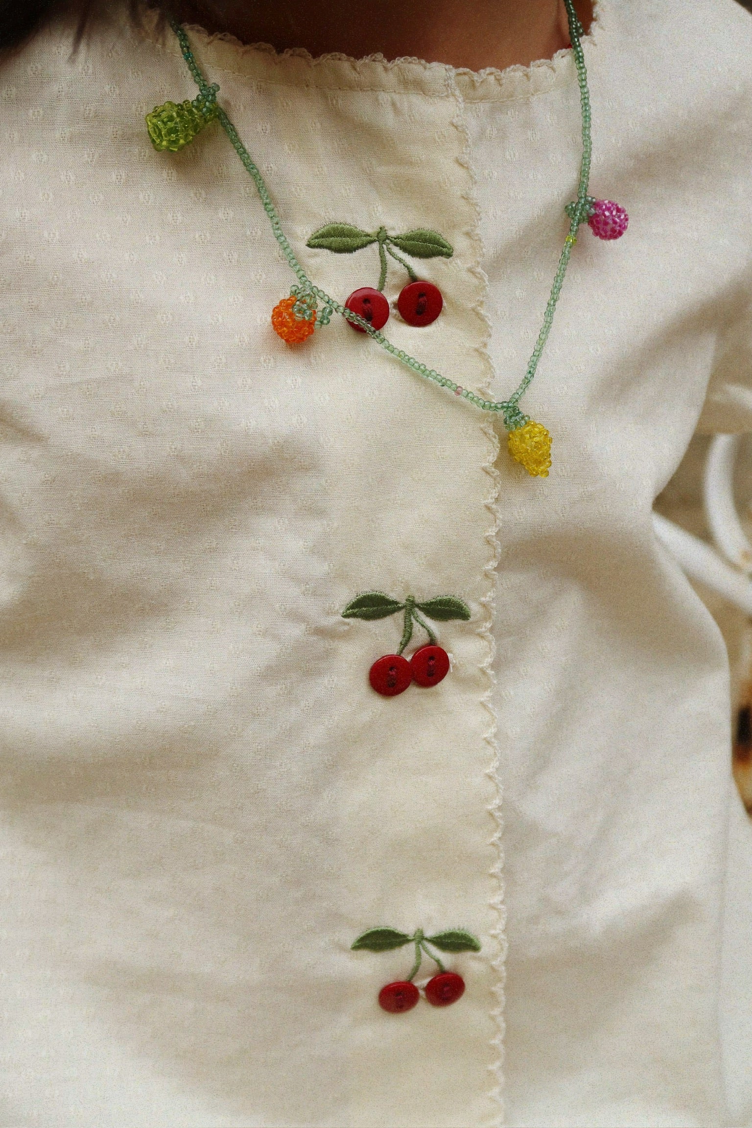 Close-up of Evia Cherry Dress cherry embroidery by Konges Sløjd, soft fabric for baby skin