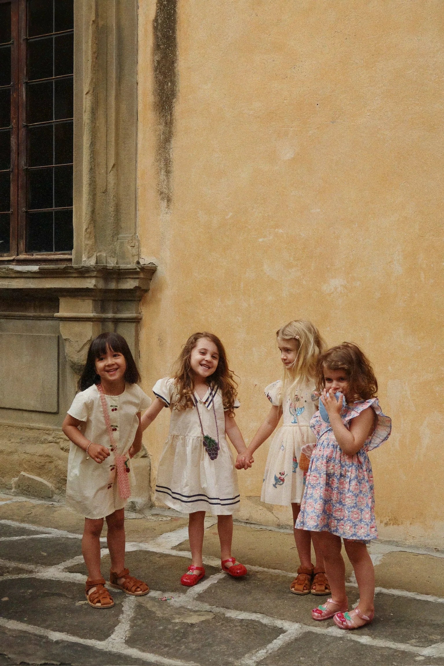 Child wearing Evia Cherry Dress by Konges Sløjd outdoors, lightweight toddler dress for warm days