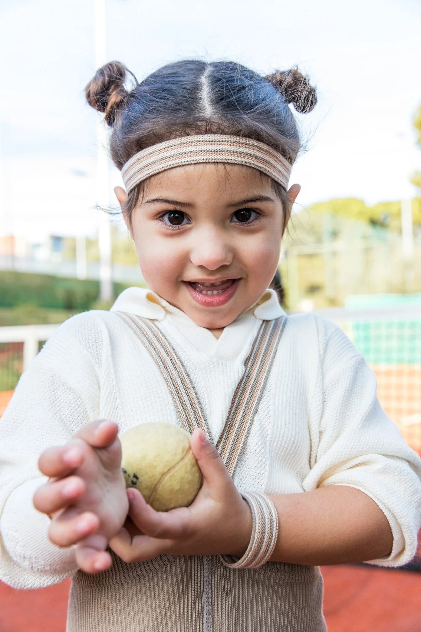 Child wearing Silly Silas footless striped tights with braces playing with a tennis ball