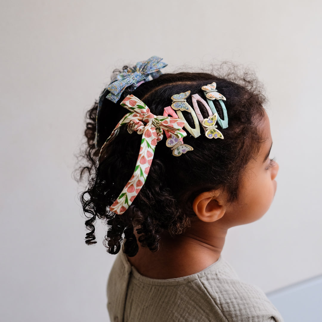 girl wearing Mimi and Lula floral bow scrunchies