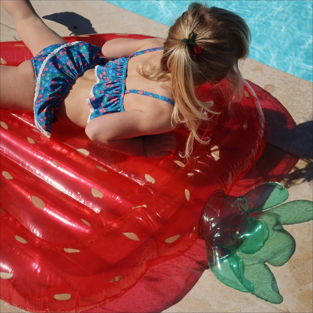 child playing with Konges Sløjd strawberry inflatable pool float