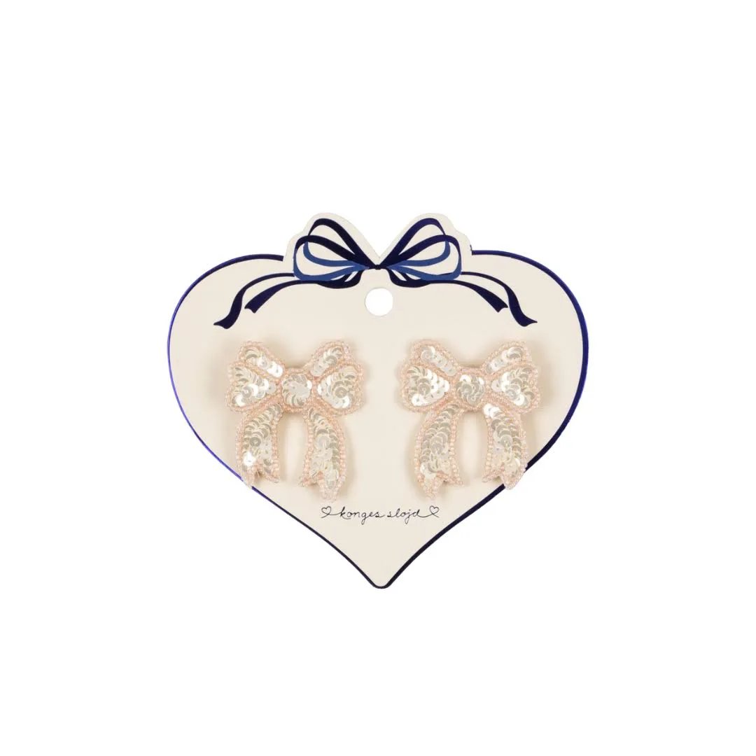 Konges Sløjd 2-pack white sequin bow hair clips for kids displayed on heart-shaped card