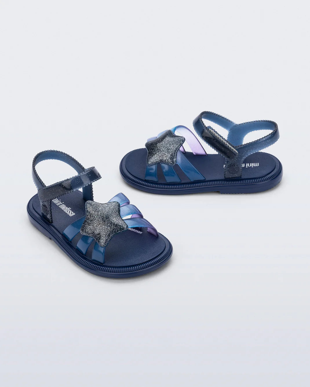 Mini Melissa Hip Sky — navy blue kids jelly sandal with two straps and bow detail, pair shown on white background