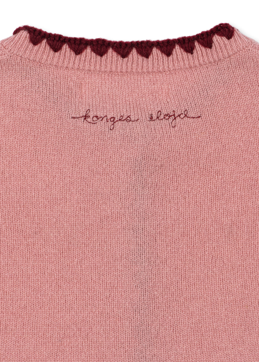 Close-up of the embroidered Konges Sløjd script and scalloped neckline