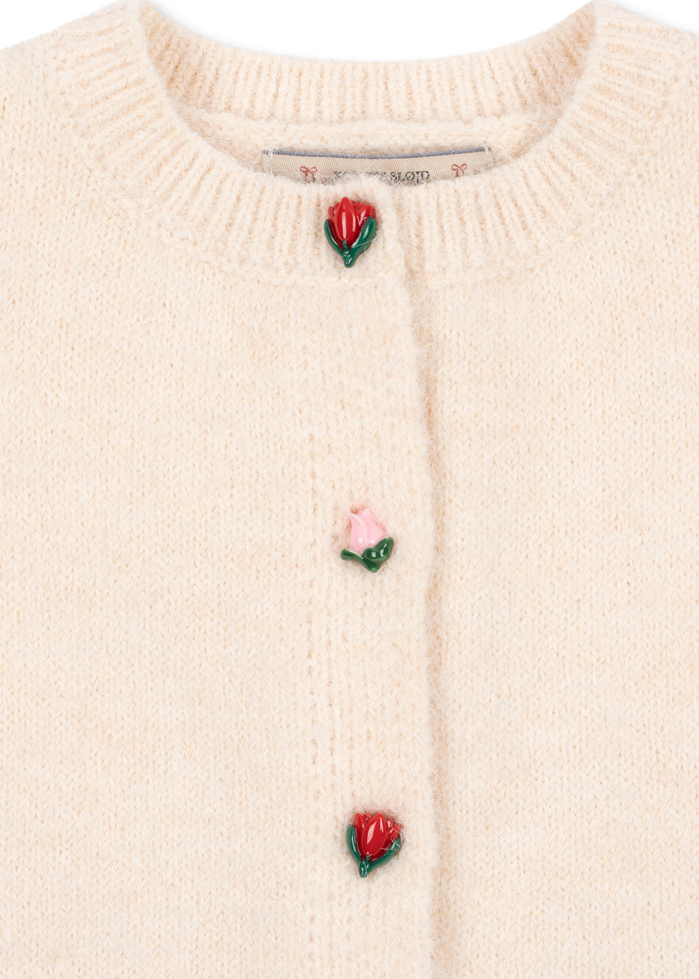 Close-up of the rosebud buttons on the cream knit cardigan