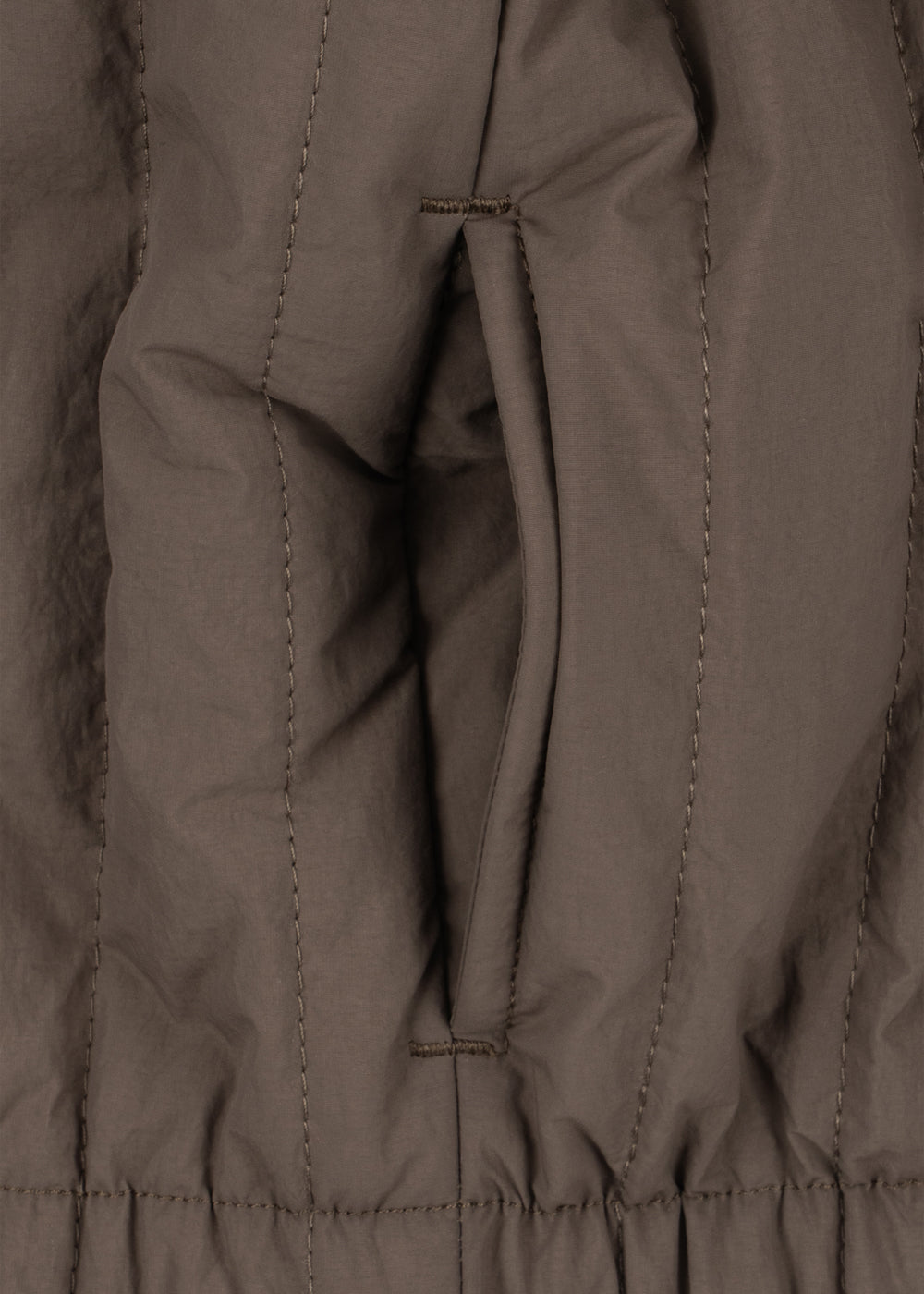 Close-up of the side pocket and elastic hem on the walnut Juno jacket