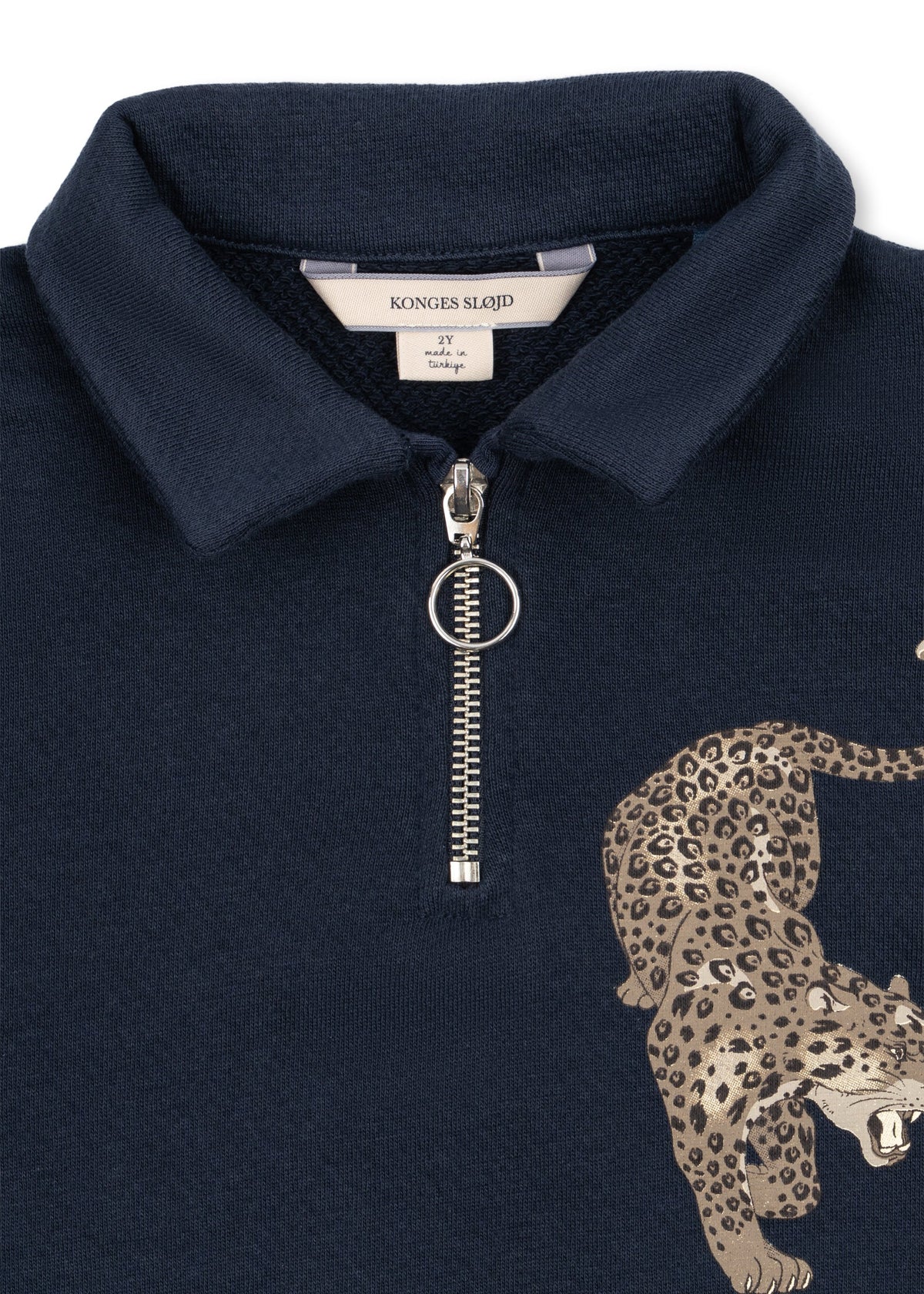 Close-up of the collar and ring-pull half zip on the navy polo sweatshirt