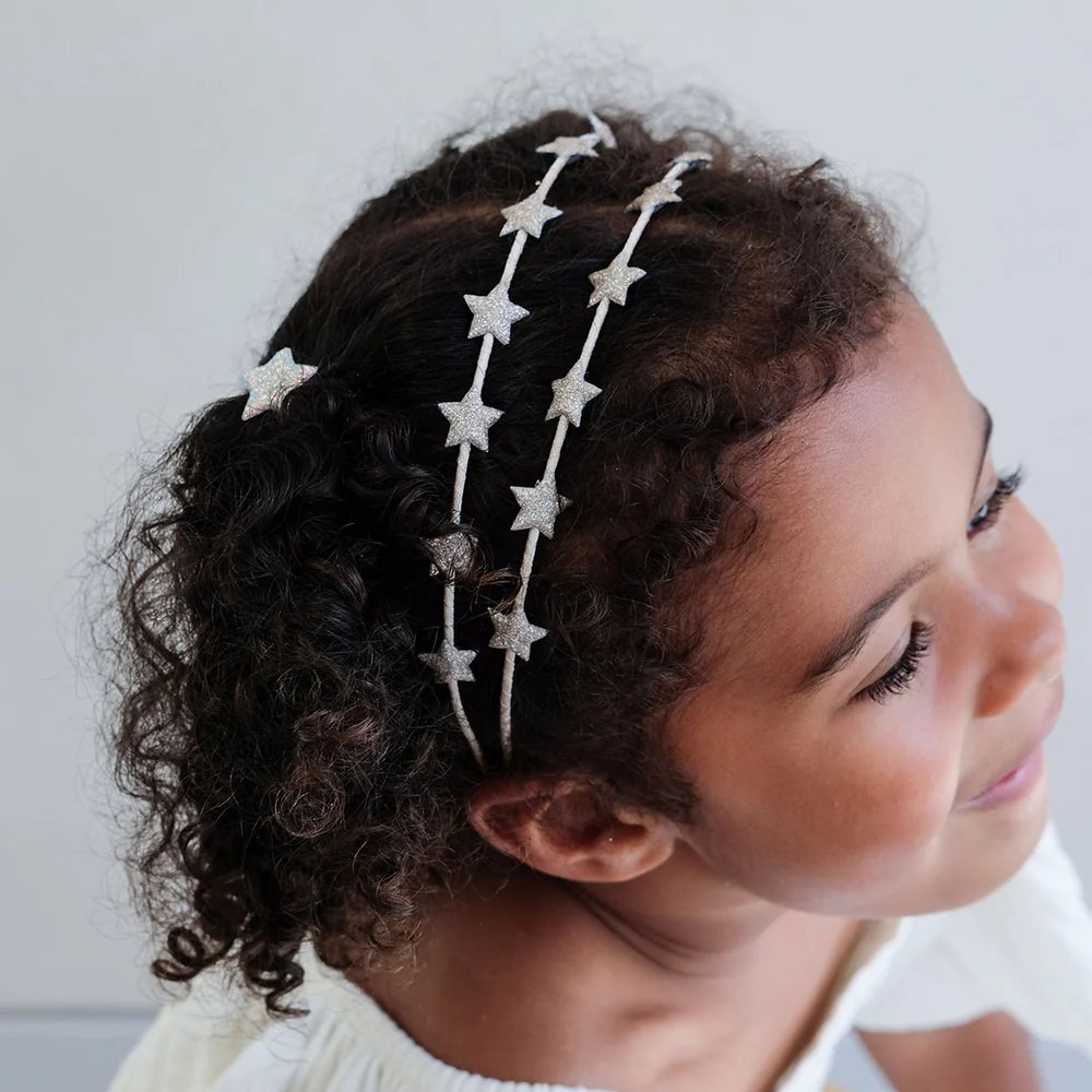 girl wearing Mimi and Lula star headband hair accessory