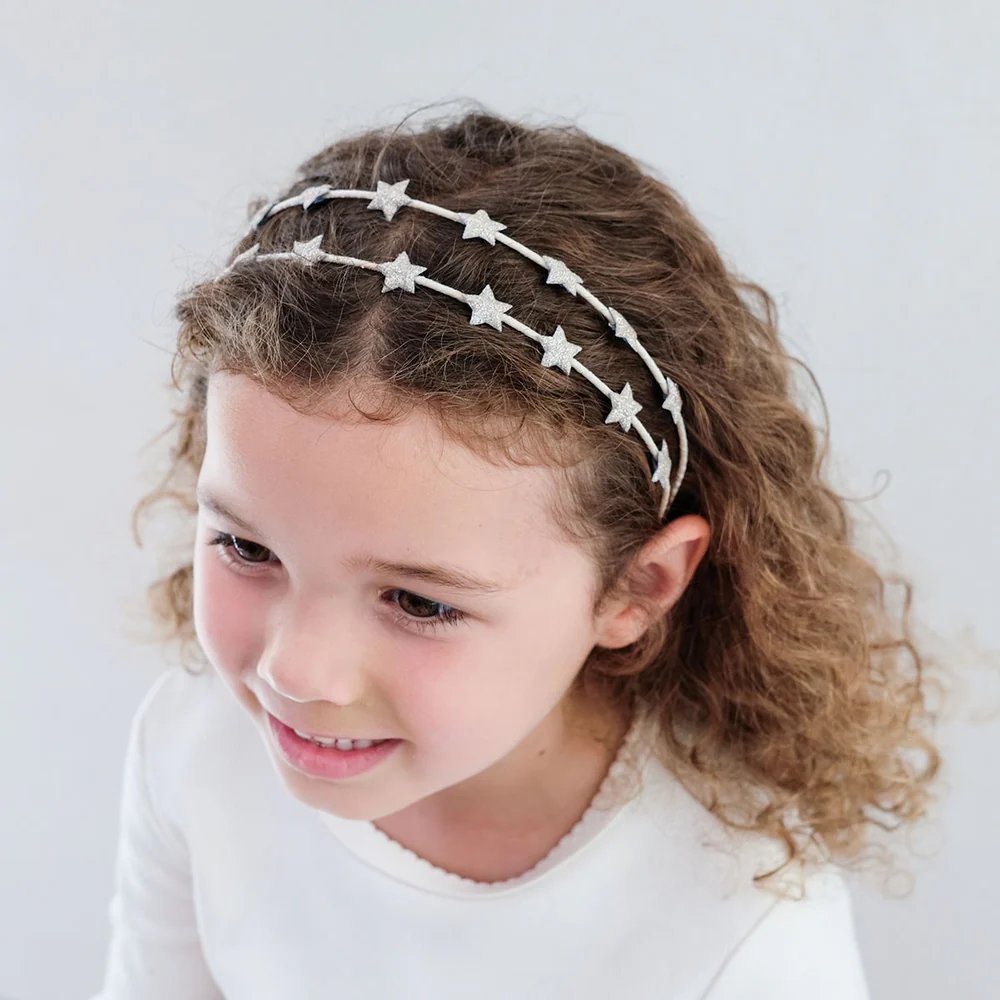 girl wearing Mimi and Lula star headband hair accessory