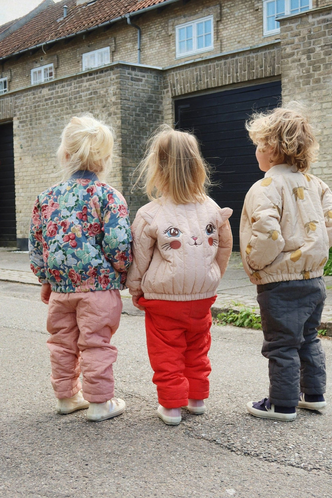 Children wearing Konges Sløjd outerwear including Juno Kitty bomber jacket outdoors
