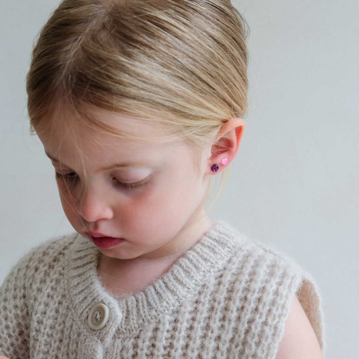Young girl wearing bright gem stick on earrings