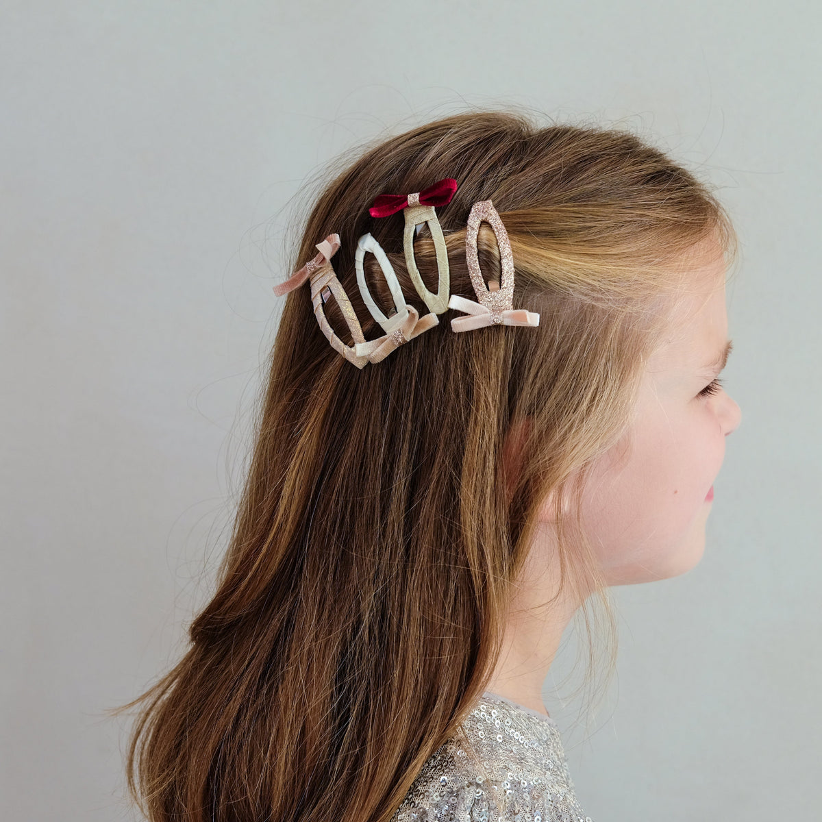 Young girl wearing skinny velvet bow hair clip