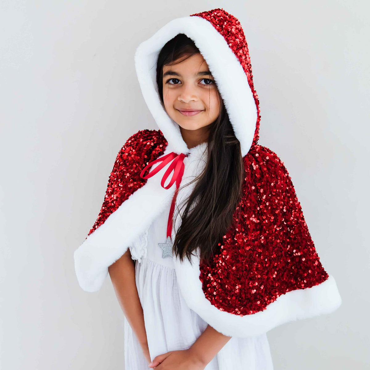 Child wearing red sequin Mrs Claus cape with faux fur trim