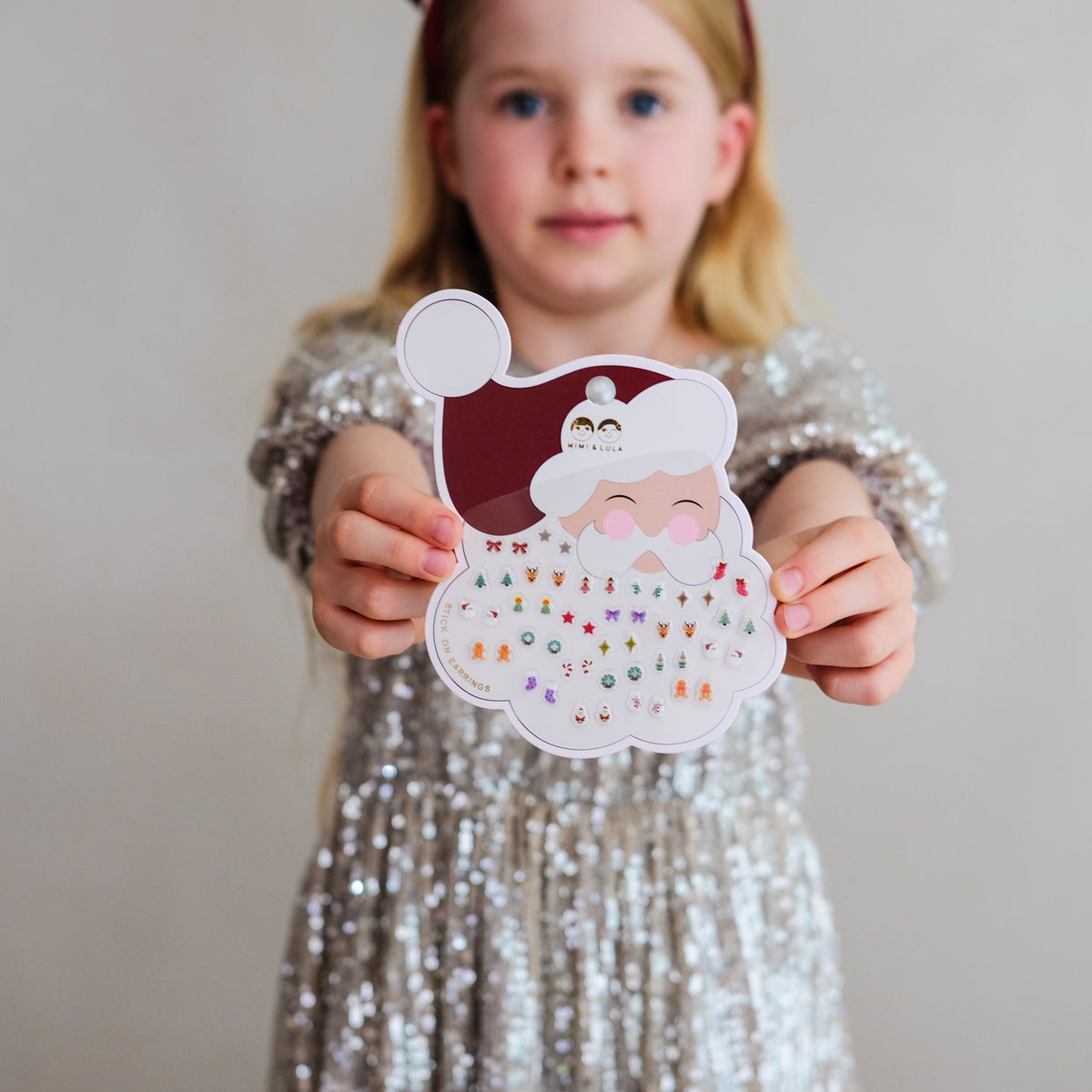 Young girl holding Santa stick on earrings
