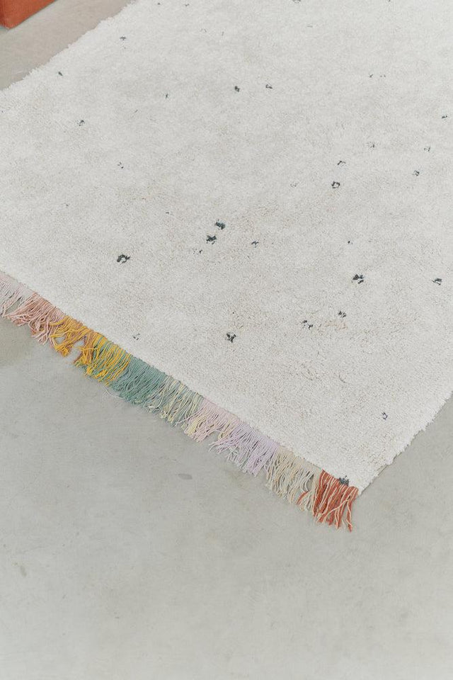 Close-up detail of Washable Cotton Rug Stardust's speckled texture by Lorena Canals