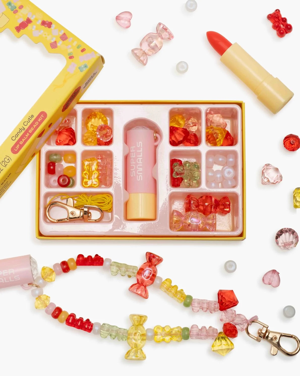 Supersmalls Candy Cutie Lip Balm Bead Kit — kids DIY lip balm and bead jewellery making kit with candy theme in red and yellow tones, shown in gift box with accessories