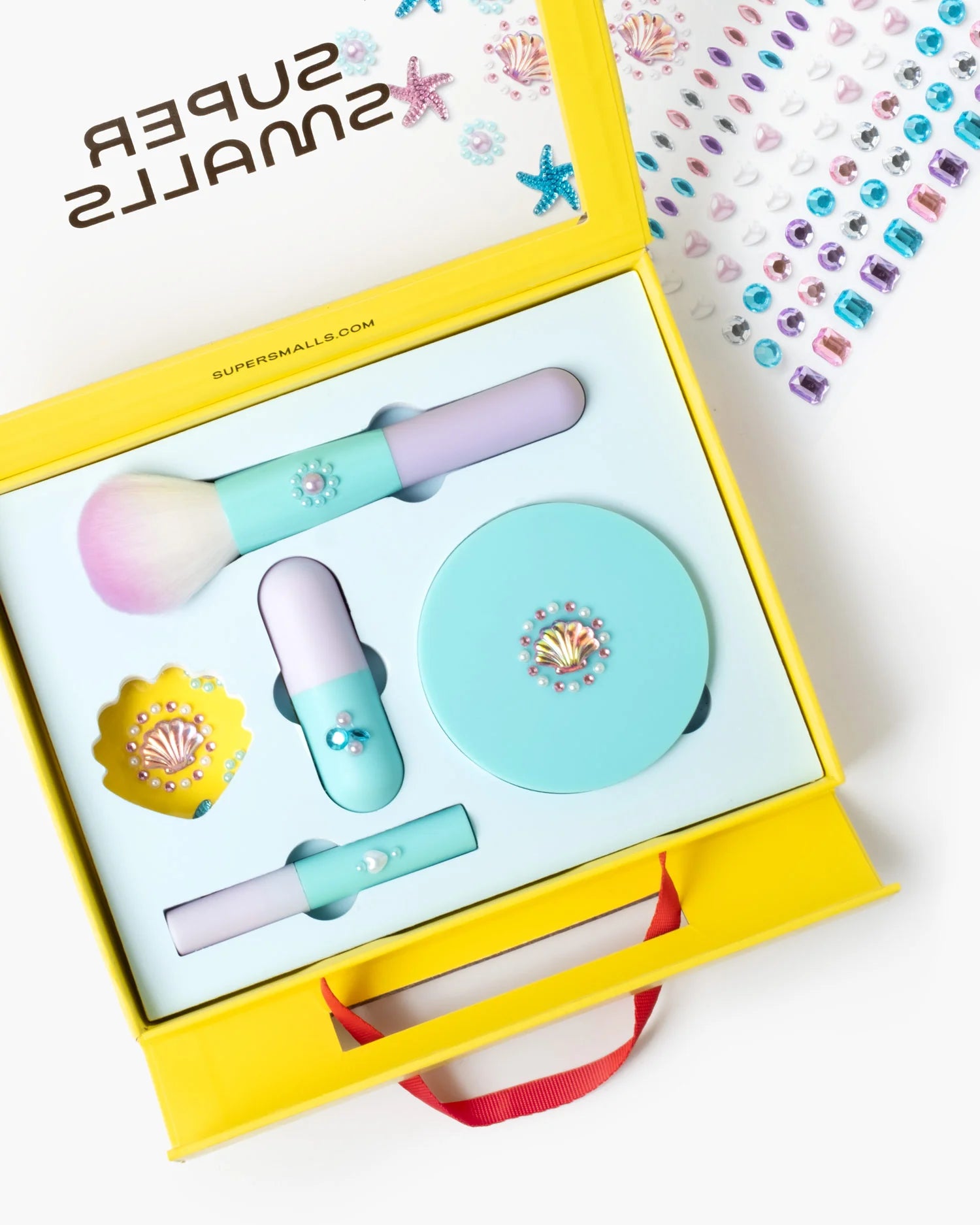 Supersmalls Mermaid Makeup Play Kit — kids mermaid-themed makeup play set with eyeshadow, lip gloss, gem stickers and glitter accessories, shown in yellow gift box