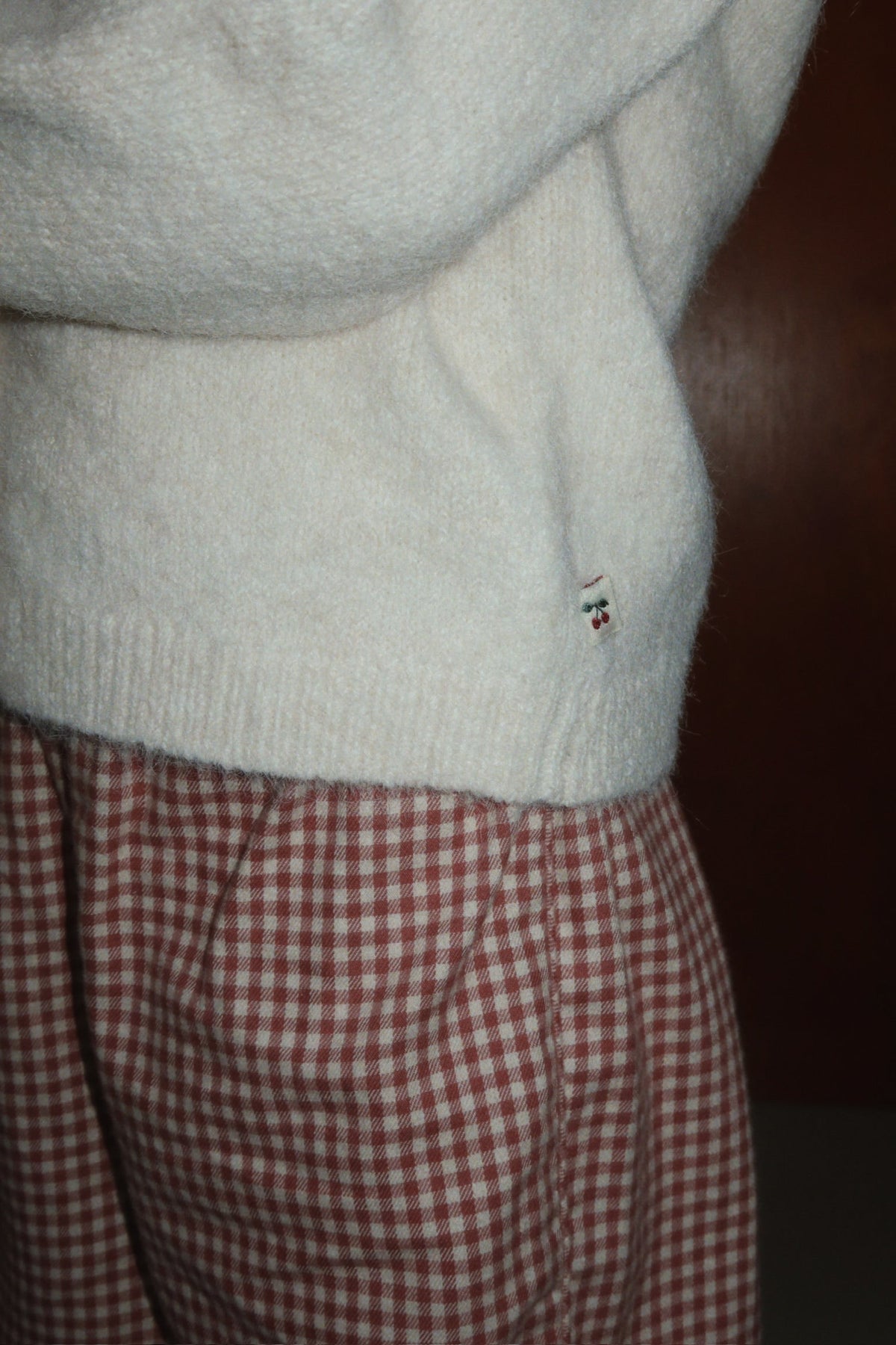 Close-up of the cardigan hem worn with gingham pants