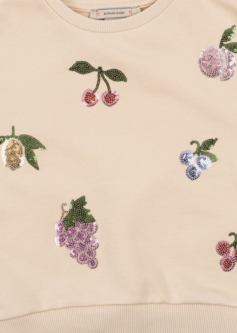 Close-up of sequin cherry and grape embroidery on Konges Sløjd Lou sweatshirt