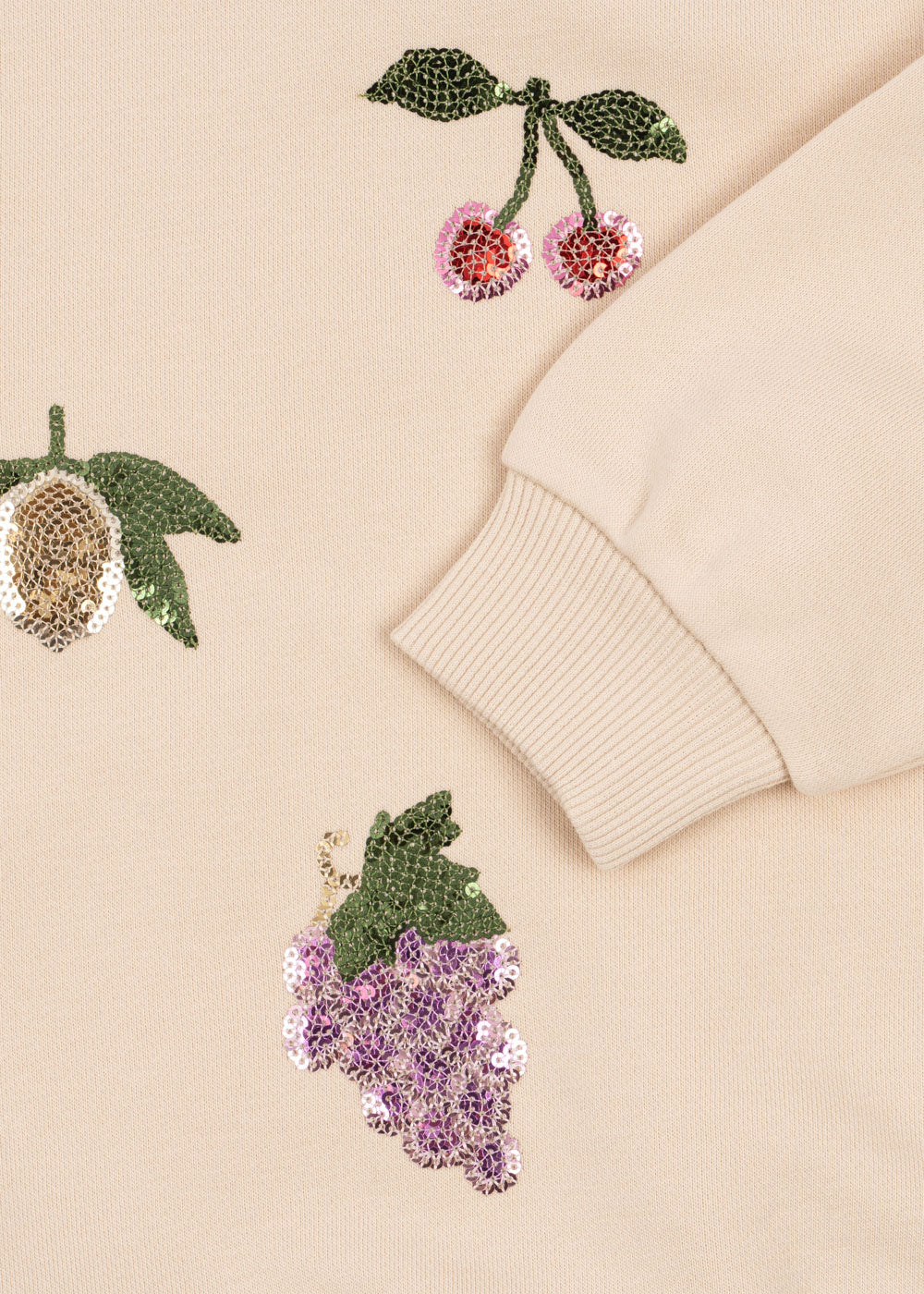 Detail of ribbed cuff and sequin fruit pattern on Konges Sløjd Lou sweatshirt