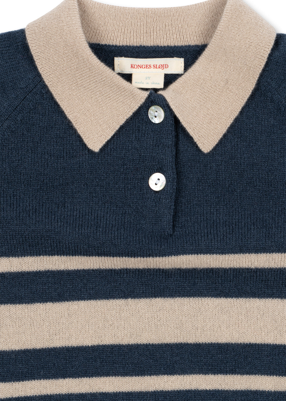 Close-up of the cream knit collar and button placket on the Basi polo