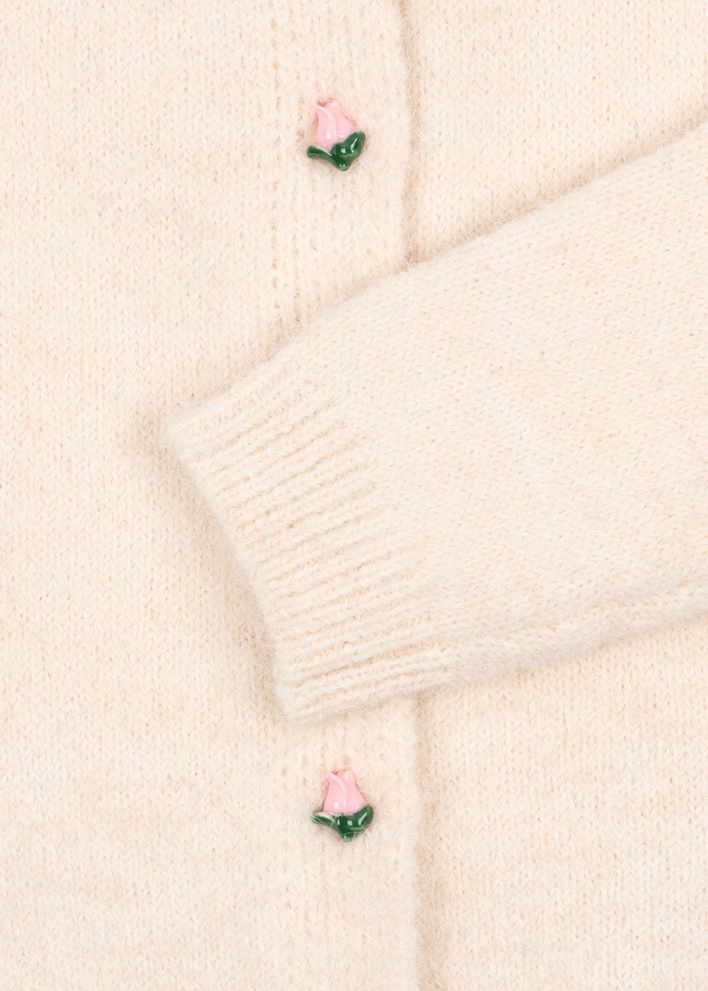 Close-up of the ribbed sleeve cuff and rosebud button