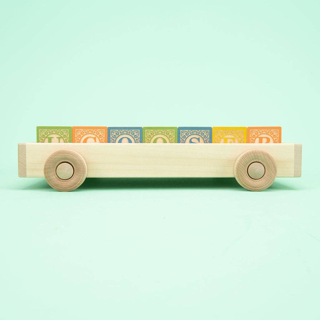 Close-up of Classic ABC wooden blocks showing embossed letters and hand-crafted animal designs