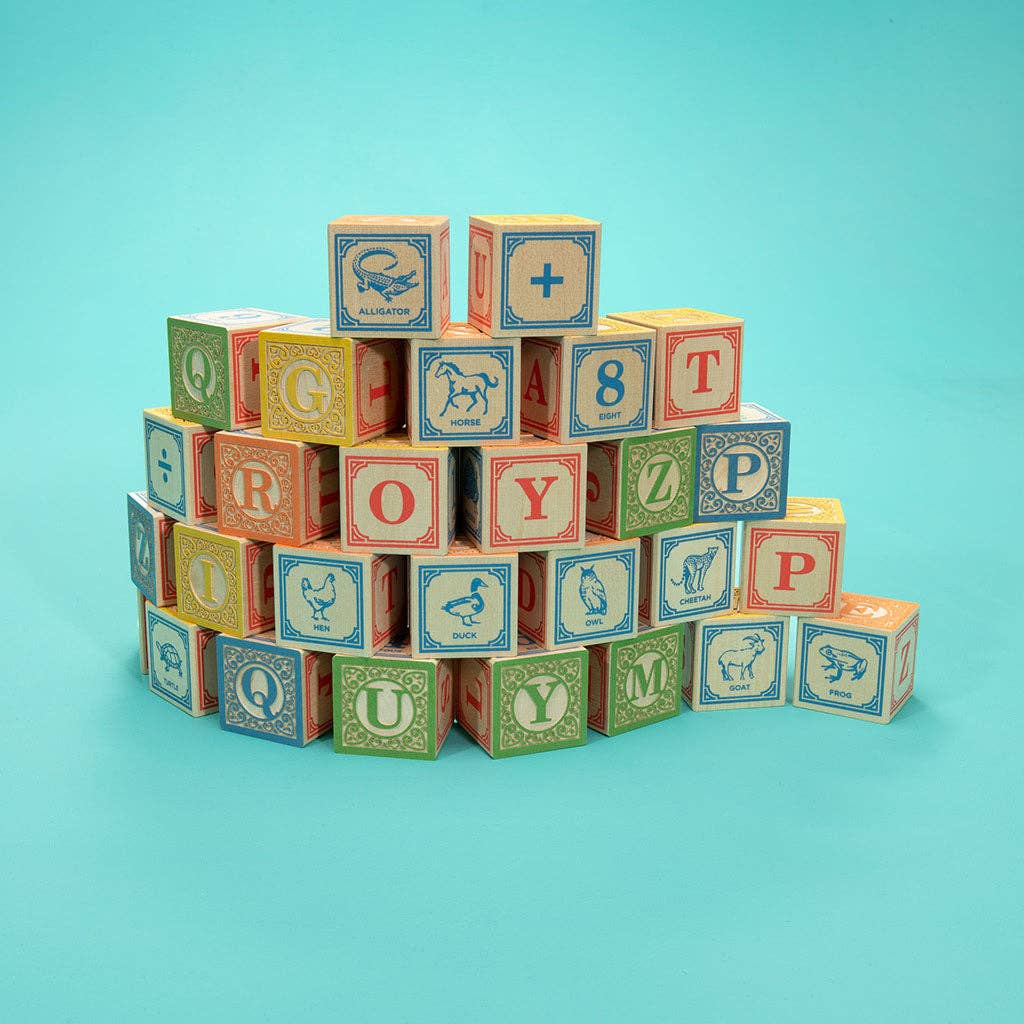 Close-up of embossed alphabet letters and hand-crafted animal designs on ABC blocks