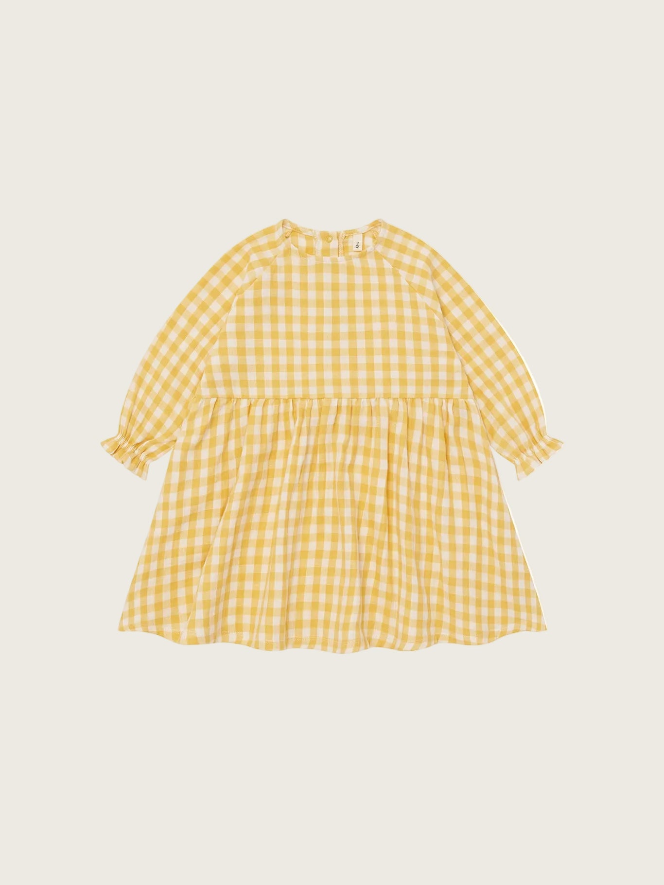 Organic Zoo Honeycomb Gingham Field Dress in honeycomb yellow — soft organic muslin long-sleeve girls dress with relaxed fit, flat lay on beige background