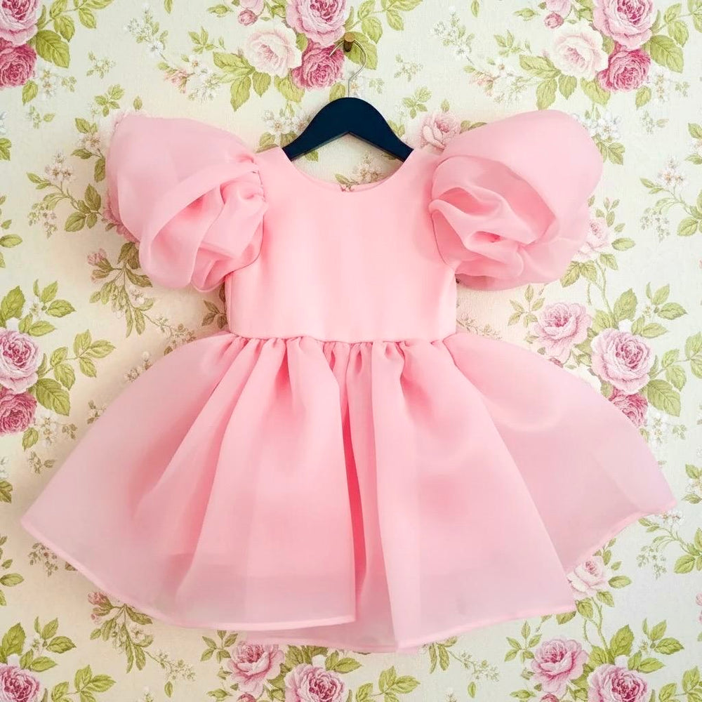 DOLLY by Le Petit Tom V-Back Puff Sleeve Organza Tutu Dress in Donut Pink — signature puff sleeve organza tutu dress for girls, hanging on hanger