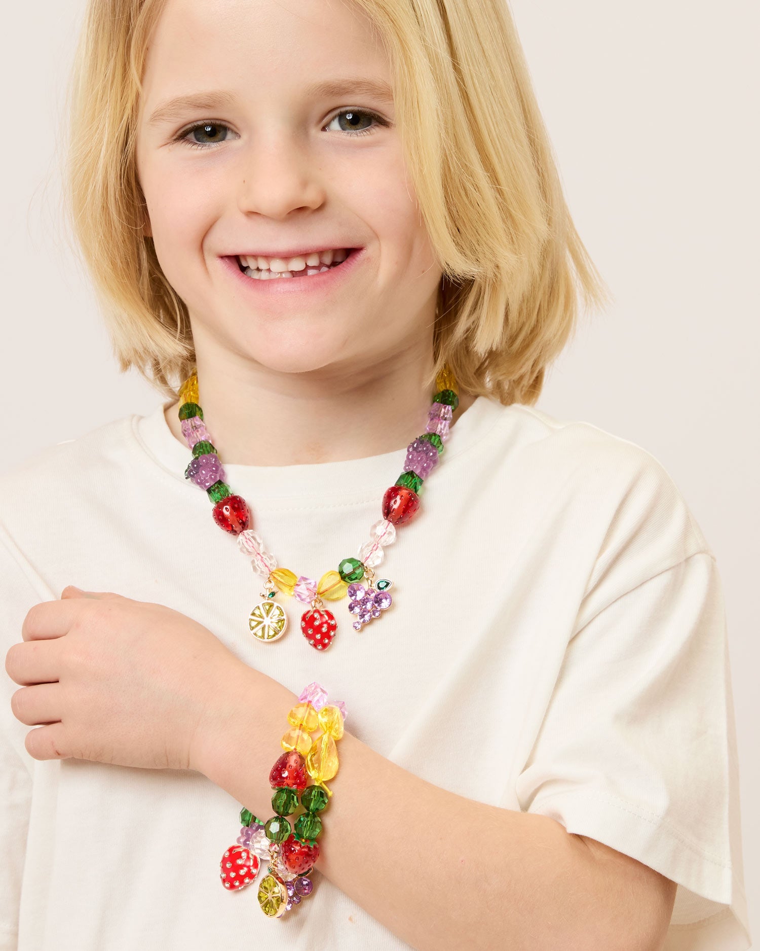 Child wearing colorful fruit-inspired bead jewelry from Super Smalls Make It Fruity Mini Bead Kit